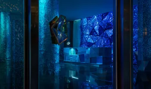 A minimalist hotel lobby featuring glass walls and geometric designs.