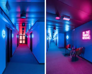 A minimalist hallway with modern design elements and bright, colorful lighting.