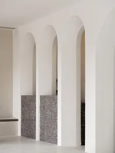 A modern interior with concrete arches and textured walls