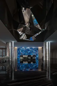 A modern lobby with marble columns and a glass ceiling.
