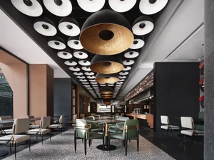 A modern restaurant dining room with metallic lights, black and gold accents, and leather chairs.