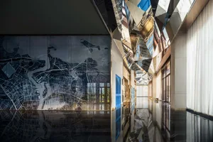 A modern interior design featuring a glass ceiling that creates reflections on the corridor floor.