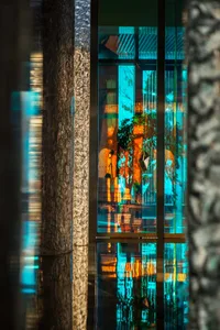 Modern retail store interior with large glass windows reflecting urban scenery and interior design elements.