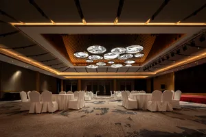 A conference room with tables and chairs covered in white cloth.