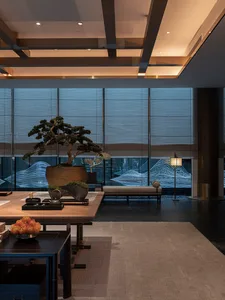 Modern living room featuring a wooden coffee table, stone fireplace, and metal accents.
