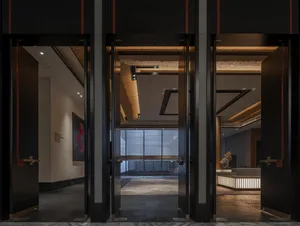 A modern lobby featuring metal walls and wooden ceiling beams.