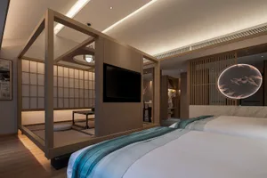 A modern bedroom featuring traditional Japanese design elements such as tatami mats, wooden frames, and a glass wall.