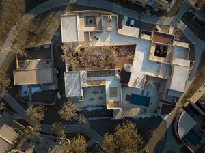 Aerial view of a modern building roof featuring decorative concrete elements and a central circular structure.