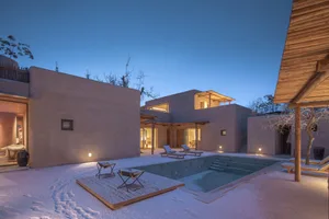 Rustic residential architecture with concrete walls and a swimming pool.