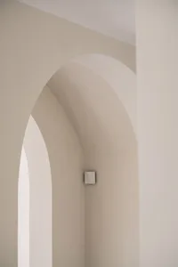 A photograph of an architectural interior with concrete archways and minimalist design elements.