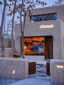 A minimalist retail storefront with a concrete exterior and warm indoor lighting.