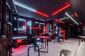 Industrial-style restaurant interior with metal pipes and neon lighting