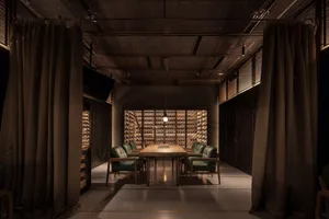 An industrial-style wine-tasting room with metal shelves and wooden furniture.