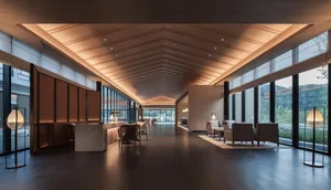 Modern hotel lobby with wood paneling, glass windows, and concrete flooring