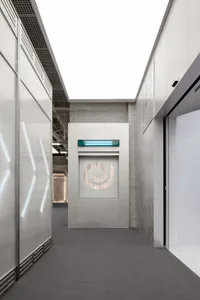 A sleek, modern industrial office entryway with concrete walls, glass panels, and minimalistic design.