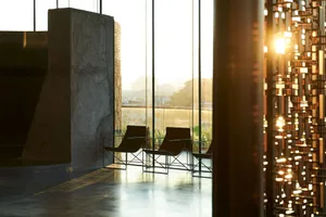 A modern interior space with concrete, glass, and metal elements designed for relaxation space.