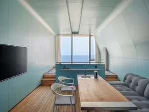 A modern minimalist living room with ocean views, featuring wood paneling and curtains, designed with clean lines and simple