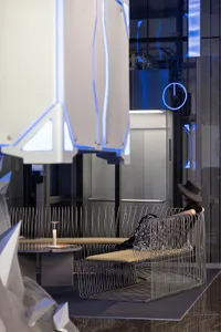 A modern, minimalist corporate lobby with metallic wire mesh seating and sleek design elements.