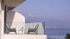 Modern vacation home with a glass balcony overlooking the sea.