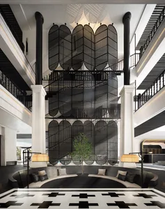 A modern hotel lobby featuring a black metal and wood design with a large planter and seating area.