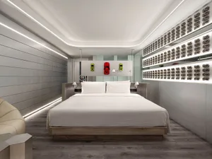 Modern residential bedroom with gray walls, metallic accents, and a wooden bed frame.