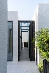 A modern residential entrance with concrete walls and large glass panels.