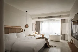 Modern bedroom with textured wallpaper, white furniture, and minimalist decor.