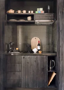 A modern, minimalist residential kitchen featuring wooden cabinets and a concrete countertop.