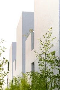 Modern building with concrete exterior and green foliage.
