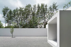 Modern architectural exterior featuring white walls and concrete elements.