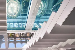 A modern building interior with a glass ceiling and lighting fixtures.
