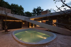 Modern house exterior with concrete bridge at night