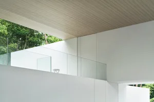 A minimalist design featuring white walls and glass elements.