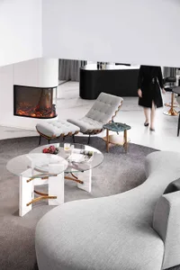 A modern living room featuring glass tables, marble accents, and metal frames in a contemporary design.