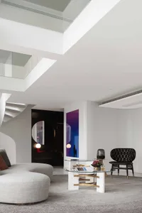 Modern loft interior with marble flooring, glass walls, and leather seating.