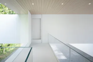Modern minimalist loft interior with concrete, glass, and wooden elements.