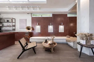 A modern retail storefront with concrete walls, minimalistic décor, and sleek furniture.