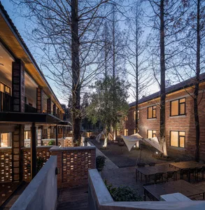 Modern brick and concrete residential architecture with outdoor seating and trees