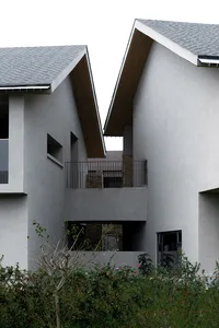 An exterior view of a modern building featuring concrete and glass materials.