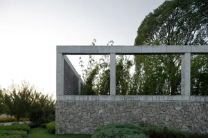 Modern concrete architectural structure with greenery in the background.