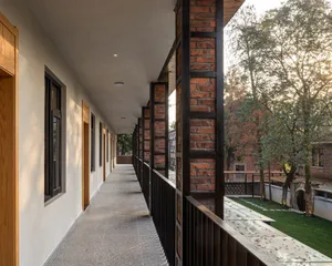 A modern corridor with brick and metal railings and doors.