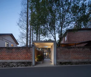 Modern architectural entrance with concrete structure and brick walls.