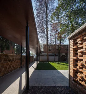 Modern exterior of a building with brick walls and a green lawn.