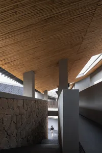 現代室內空間，搭配木質天花板與石材牆面。