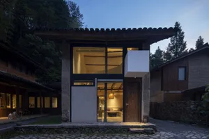 Clay brick residential exterior with traditional architecture and large glass windows.