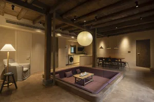 Industrial-style living room featuring a large sofa with wooden legs and a wooden floor.