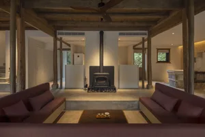 Industrial-style living space featuring concrete and wooden materials and a central fireplace.