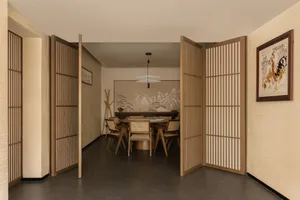 A minimalist dining room featuring wood paneling, with a table and chairs.