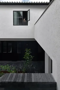 Modern minimalist residential space featuring a white wall and concrete floor.