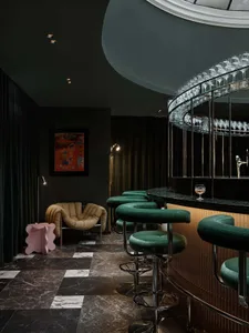 Modern bar interior featuring greenemesh bar stools and a glass bar display.